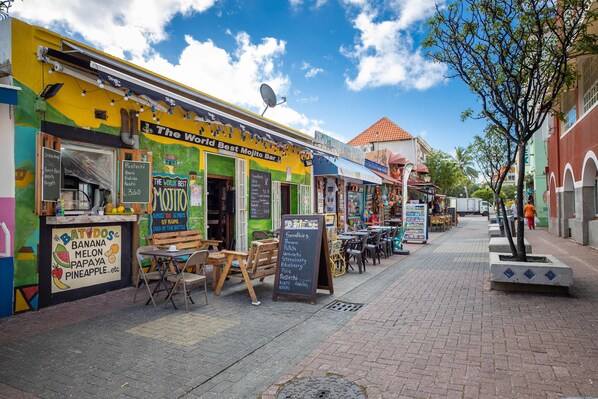 A colorful food truck named "The World Best Mojito Bar" with a menu board listing items like banana, melon, papaya, and pineapple. - Chic City View Residence by the Bay (Willemstad)