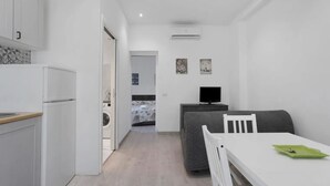 A compact living space with a kitchenette, a dining area, and a bedroom. - Lambrate Flat Milan (Milano)