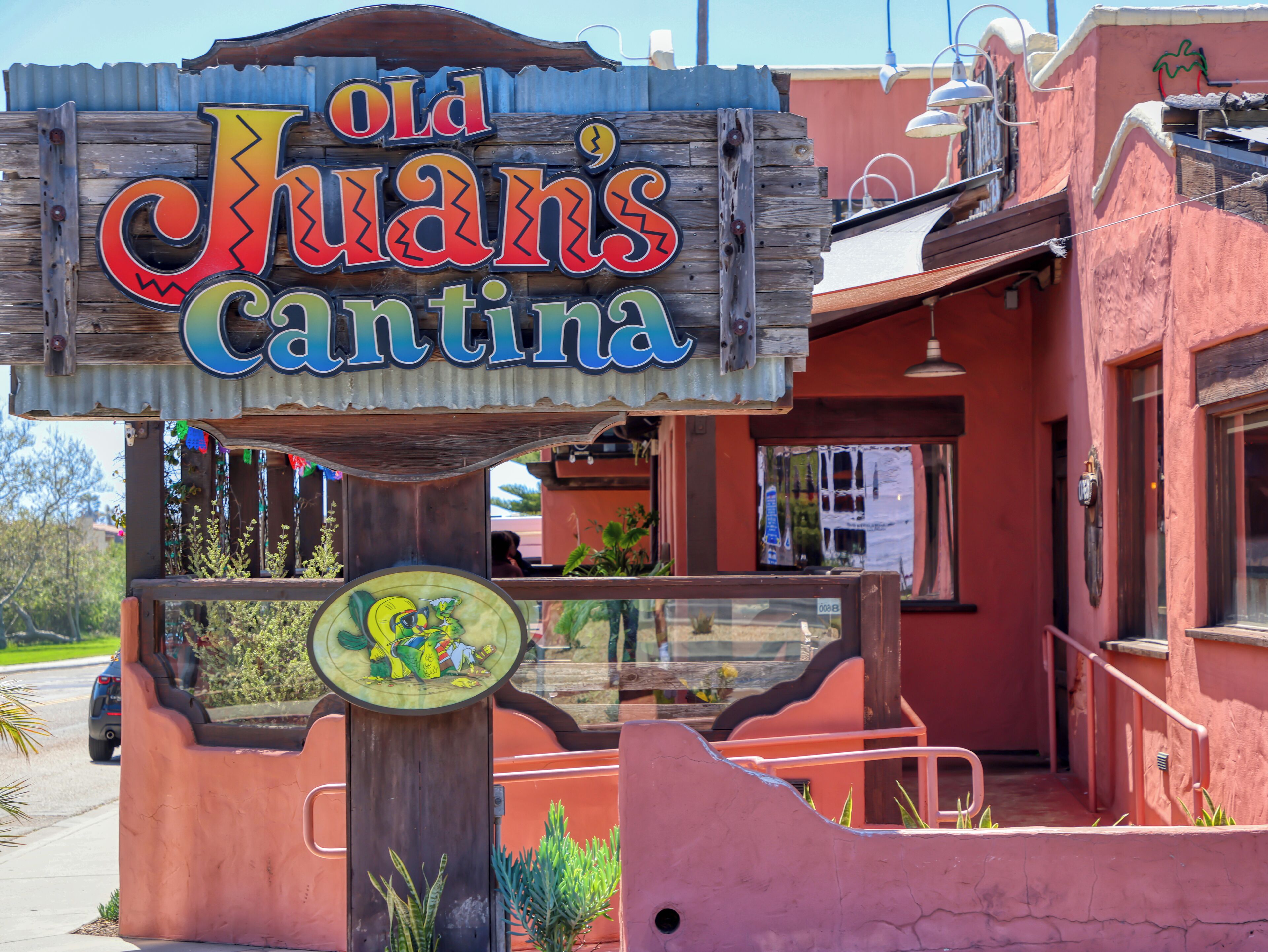 Un cartello di legno con lettere colorate che indica 'Old Juan's Cantina'.