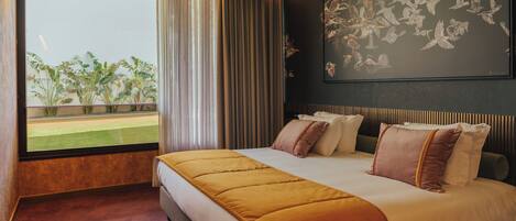 Habitación de hotel con una cama grande, vistas al exterior y una obra de arte en la pared.