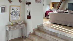Un salon moderne avec un plafond en bois, un escalier et un canapé.
