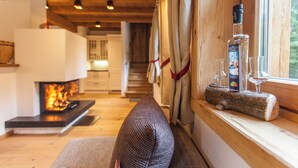 Una sala de estar acogedora con chimenea, un sofá y una ventana con cortinas.