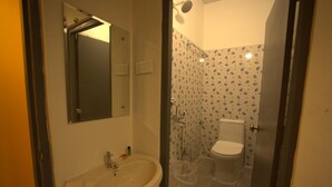 A bathroom with a sink, mirror, shower, and toilet. - Yellow Bells Signature (Hyderabad)