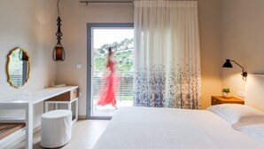 A bedroom with a bed, a desk, a chair, a nightstand, a lamp, and a window with curtains. - Cozy villa in Parga. Pet friendly! (Parga)