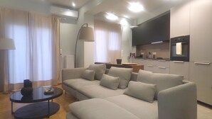 A modern living room with a grey sectional sofa, a round coffee table, and a floor lamp. - Stylish city Apartment for 4 by MPS (Athina)