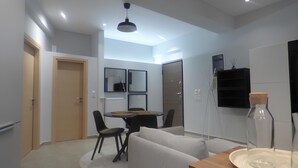 A modern living room with a sofa, a dining table with chairs, a coffee table, and a large mirror. - Stylish city Apartment for 4 by MPS (Athina)