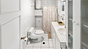 A modern bathroom with a toilet, a shower, and a sink. - Oceana Suites Casa Ñuñoa (Santiago)