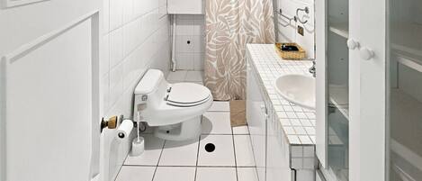Un baño moderno con inodoro, ducha y lavamanos.
