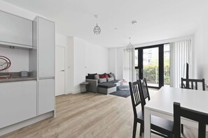 A modern apartment with a kitchen, dining area, and living room. - Modern 2 Bed 2 Bath with Patio | Close to Wembley (Greater London)