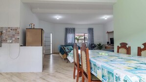A compact hotel room with a kitchenette, a dining area, and a bed. - Casa em Peruíbe a 250m da Praia com Piscina (Peruíbe)