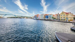 A waterfront view with colorful buildings and a bridge. - Chic City View Residence by the Bay (Willemstad)