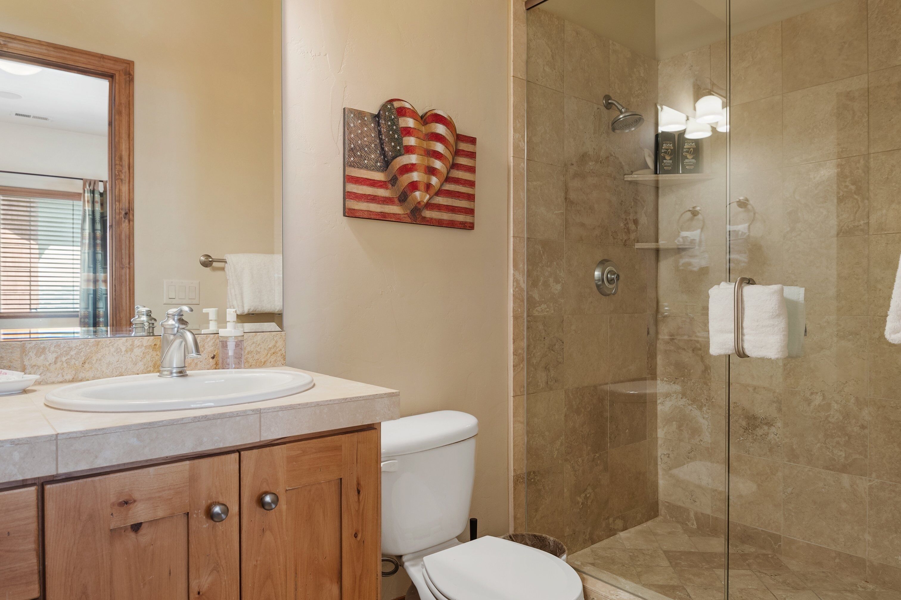 Un baño con lavamanos, inodoro y ducha.