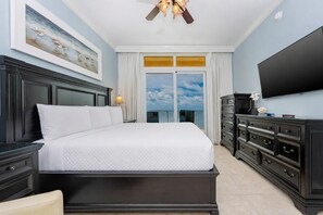 A hotel room with a large bed, a flat-screen TV, a dresser, and a painting on the wall. - Phoenix Orange Beach Ii 2702 2 Bedroom Condo (Orange Beach)