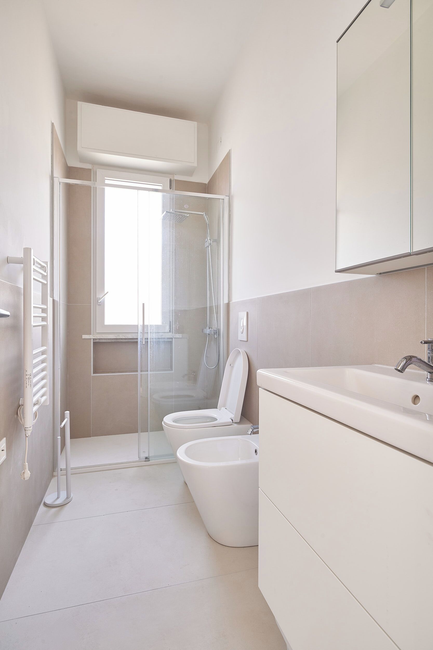 Ein modernes Badezimmer mit Duschkabine aus Glas, Toilette und Waschbecken.