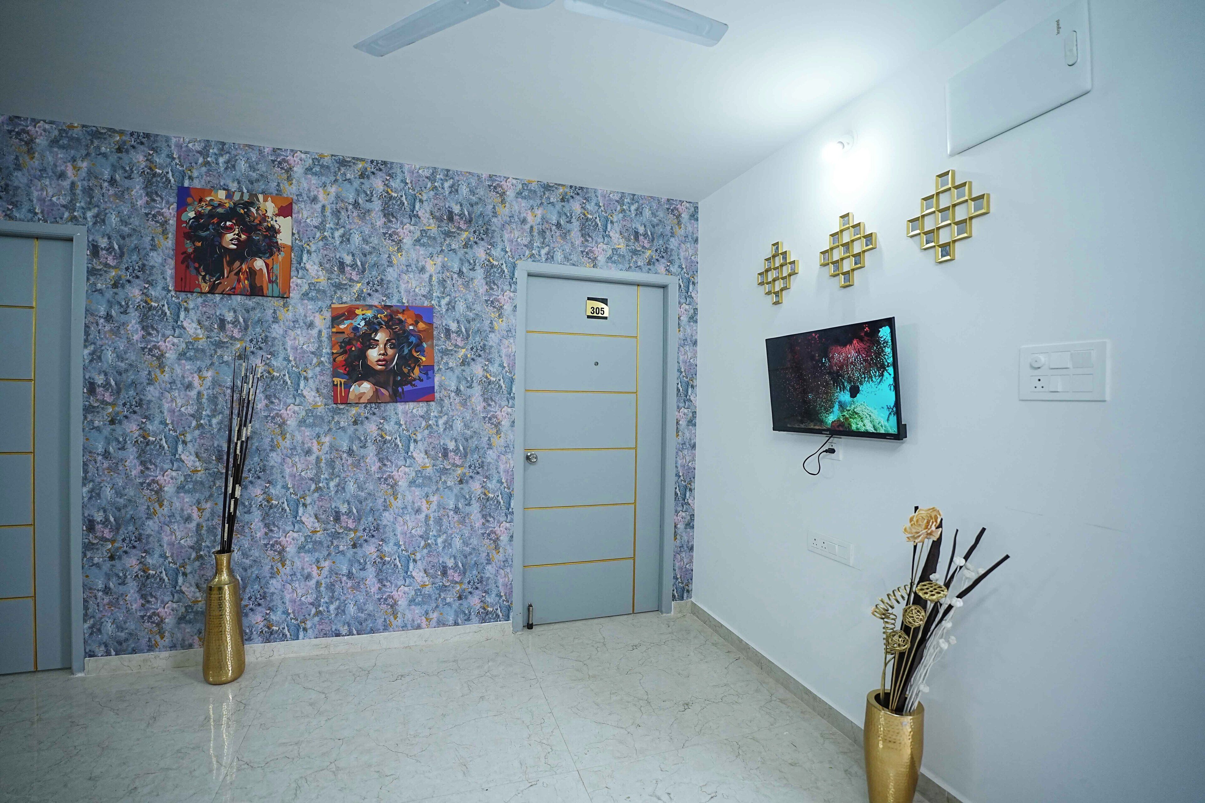 Ein Hotelzimmer mit Marmorboden, einer Tür mit Hinweisschild, zwei Gemälden, einem Fernseher und Wanddekorationen.