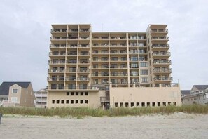 Ein mehrstöckiges Hotel mit Balkonen an jeder Etage, in Strandnähe gelegen.