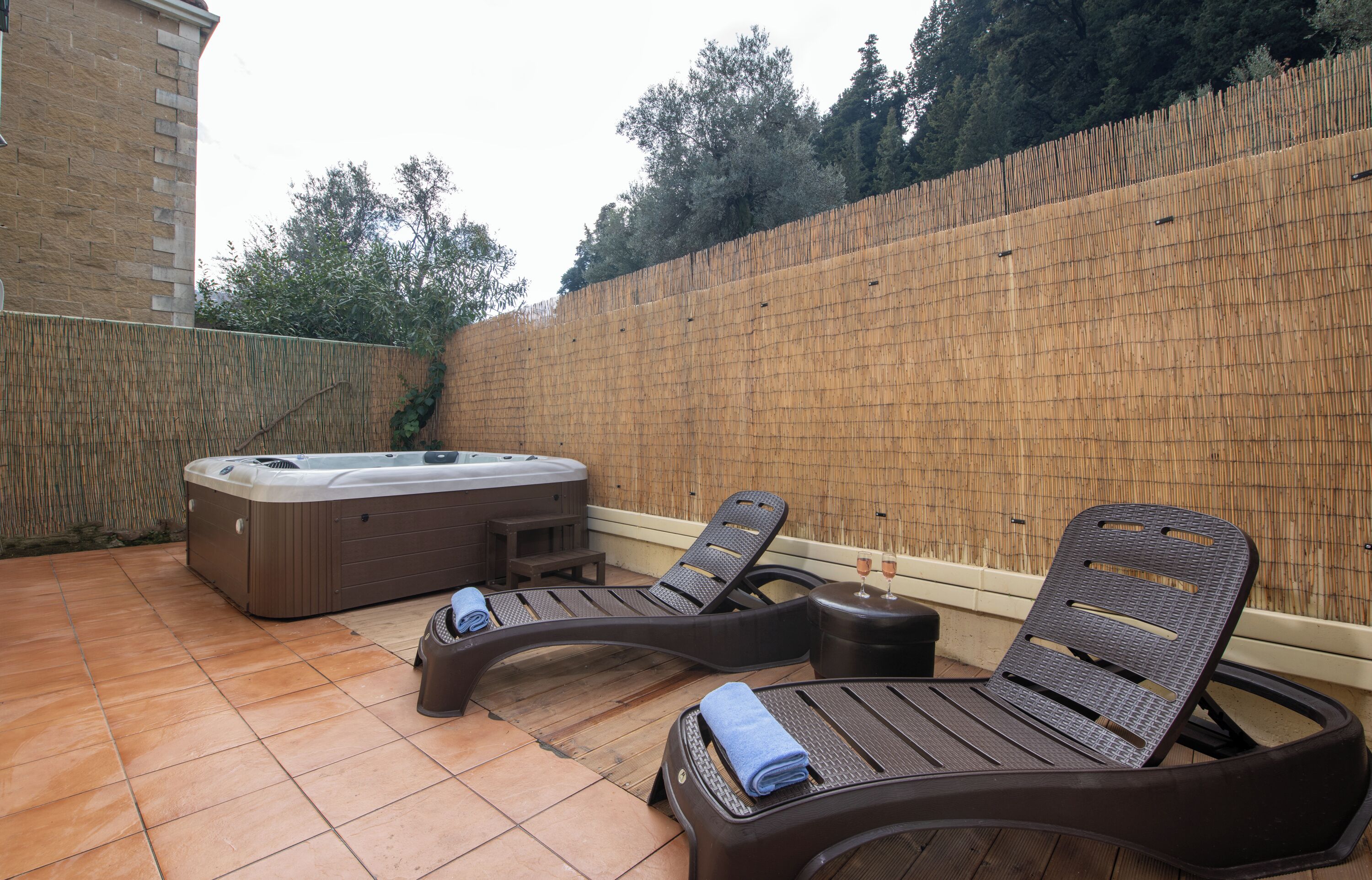 A spa area with a hot tub, two lounge chairs, and a small table.