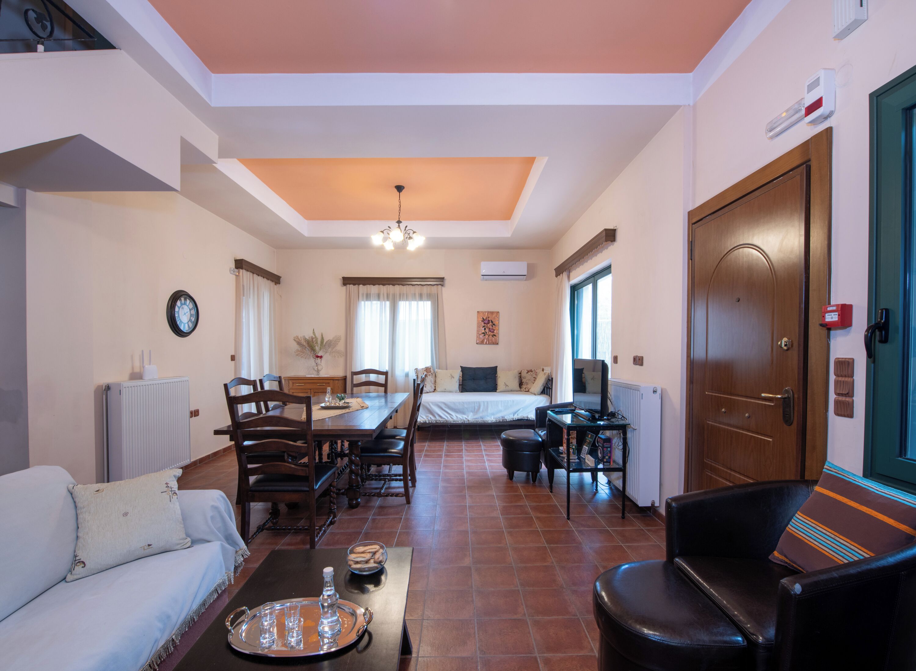 A hotel room with a dining area, a bed, a desk, and a living area.