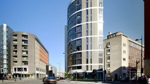 A modern building with a curved facade, multiple floors, and a mix of glass and concrete materials. - Student Only Ablett House (Liverpool)