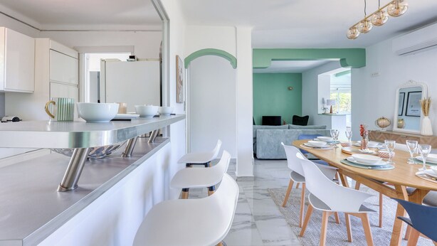 A modern kitchen with a built-in island, white cabinetry, and stainless steel appliances. - Haut de Villa Helvétie - Welkeys (Toulon)