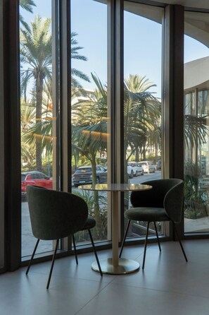 A room with large windows, two chairs, and a table. - Cento Palme (Rhodes)