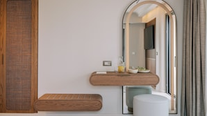 Un baño moderno con tocador de madera, un espejo grande y un banco.
