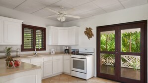 A kitchen with white cabinets, a stove, and a ceiling fan. - Rare 3BR ocean view villa with private pool (Paradise  View)
