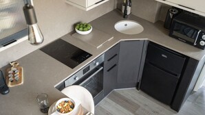 A modern kitchen with a built-in oven, microwave, and sink.
