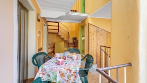 A dining area with a table set for two, chairs, and a ceiling light. - Old Pella: 100m to Lake Orta, Terrace and Views (Pella)