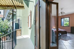 A room with a bed, a window, a door, and a balcony. - Old Pella: 100m to Lake Orta, Terrace and Views (Pella)