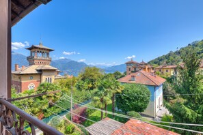A residential area with a view of mountains, a tower, and a house with a red roof.