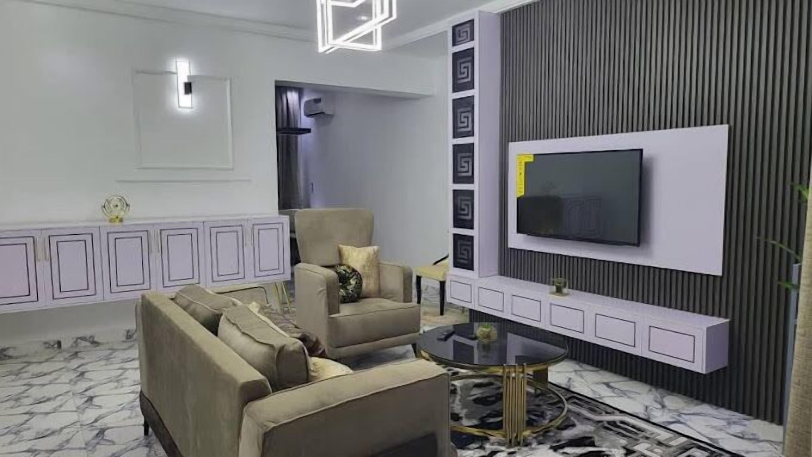 Una sala de estar moderna con un conjunto de sofá, una mesa de centro y un televisor de pantalla plana montado en una pared con paneles decorativos.