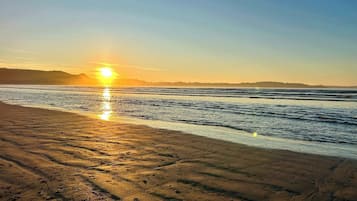 Enjoy a serene beach experience with calm ocean waves and soft sand.