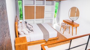 Ein Schlafzimmer mit einem Bett, einem Schreibtisch, einem Stuhl und einem Spiegel.