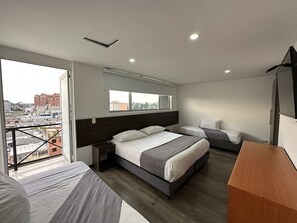 Fyrbäddsrum - balkong - utsikt mot staden | Skrivbord, mörkläggningsgardiner, strykjärn/strykbräda och gratis wi-fi