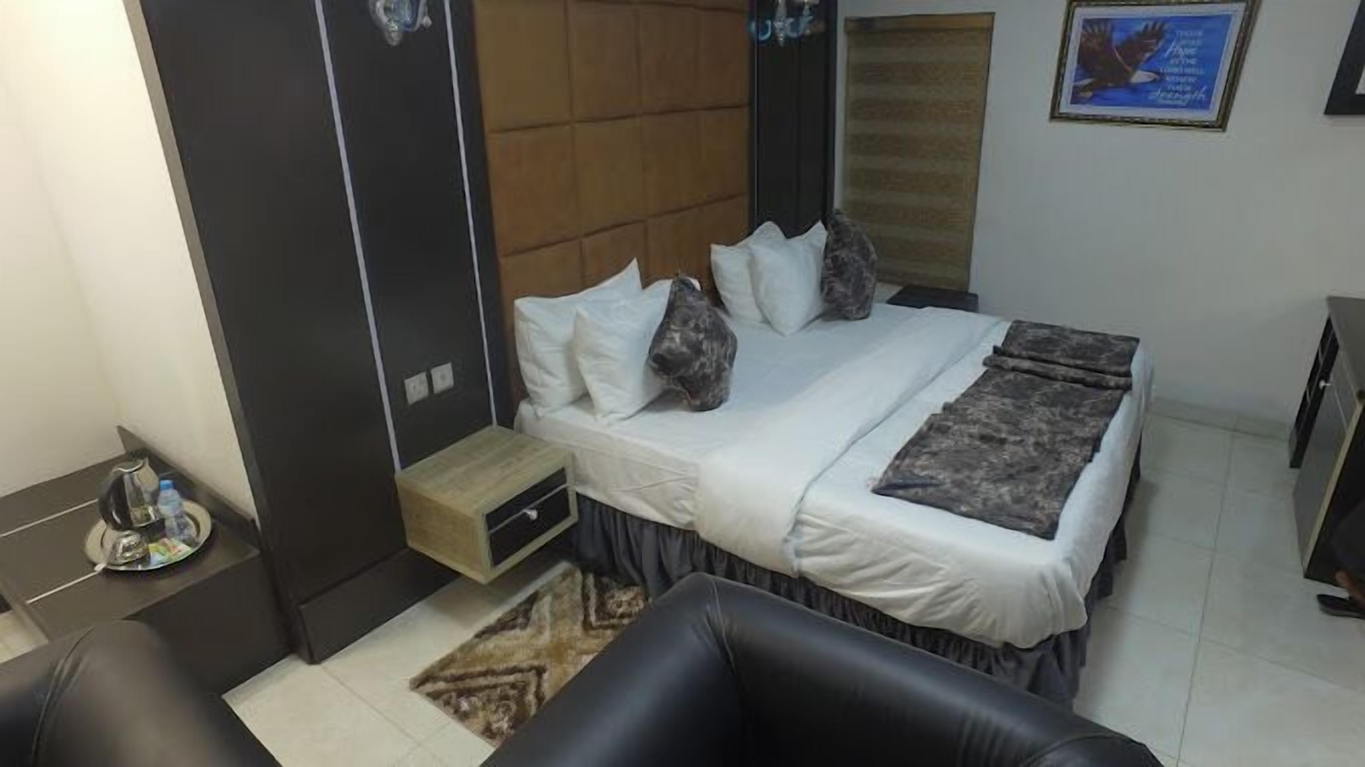 Une chambre à coucher avec un lit, des tables de chevet, une chaise et un petit tapis.