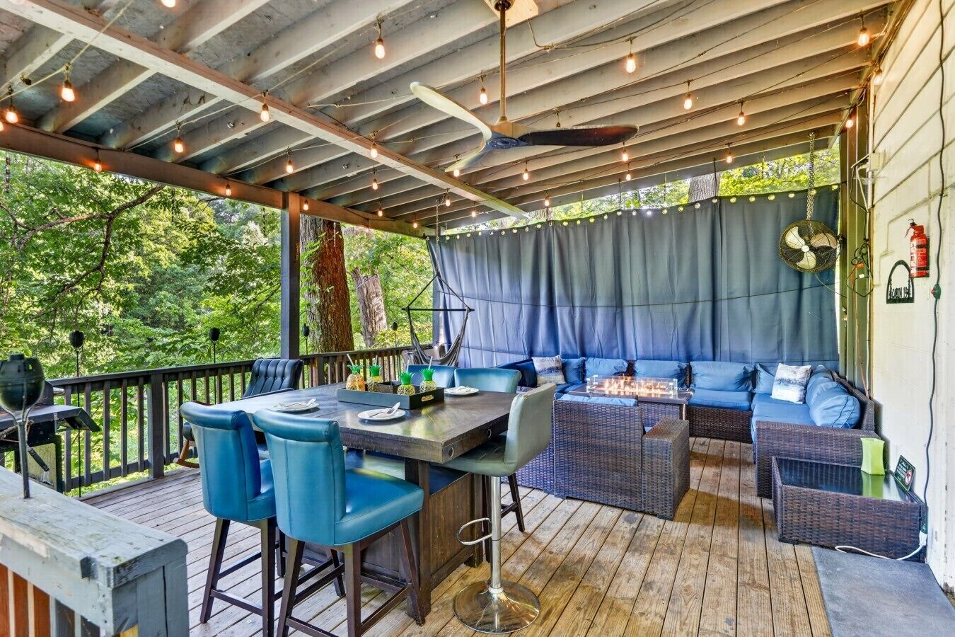 Une terrasse extérieure comprenant un espace repas, des tabourets de bar et un coin salon.