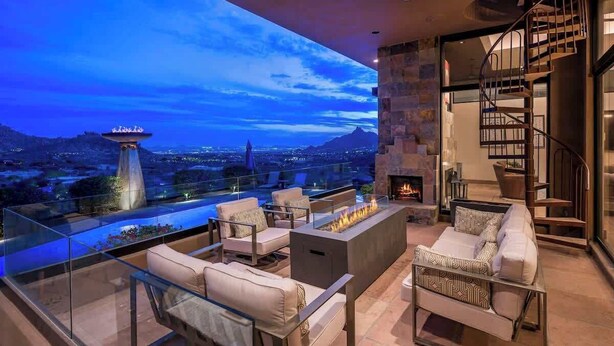 A rooftop terrace with a fire pit, seating area, and a view of the cityscape.