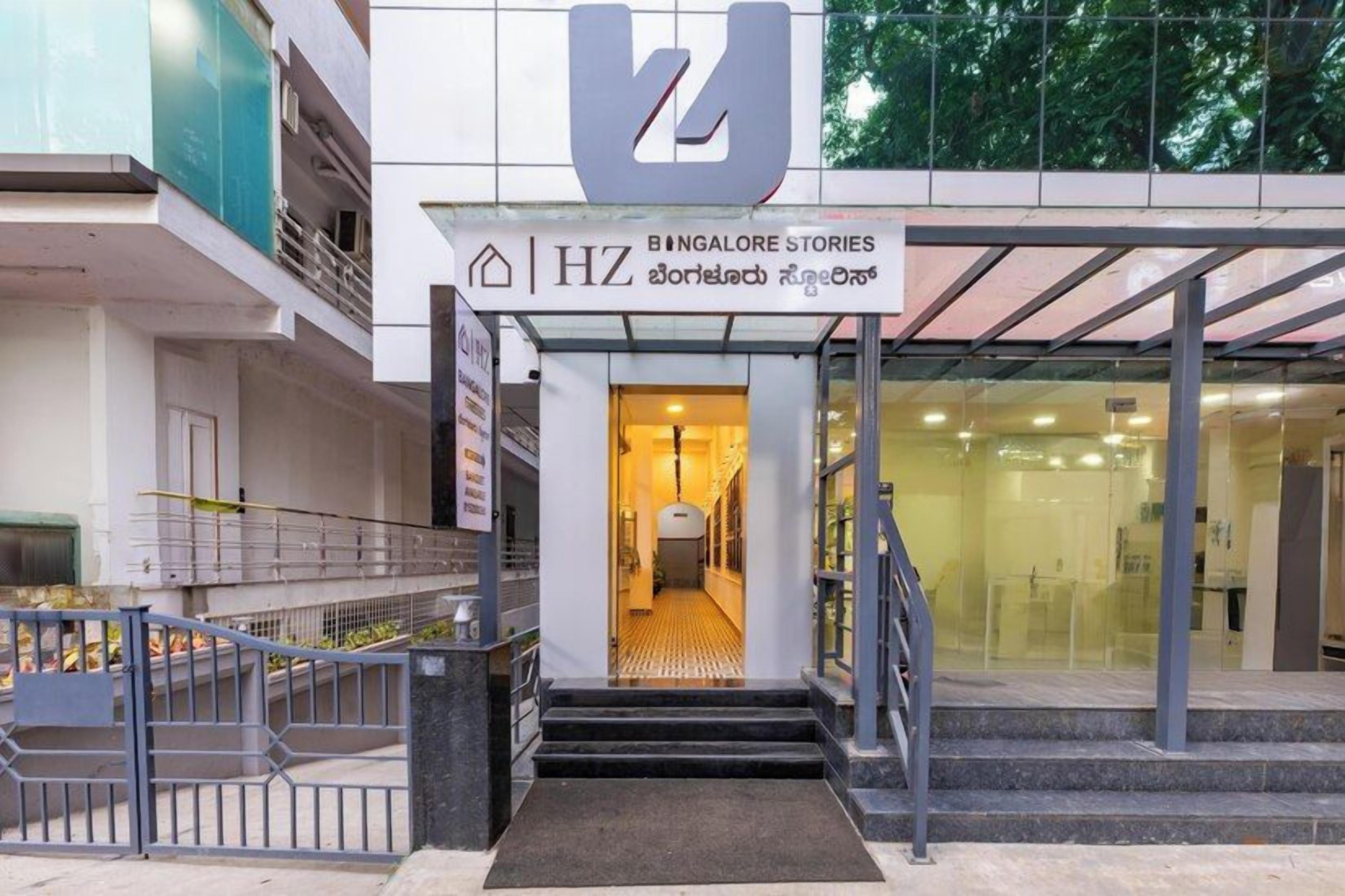 A hotel entrance with a sign reading 'BENGALORE STORIES' and a staircase leading inside.