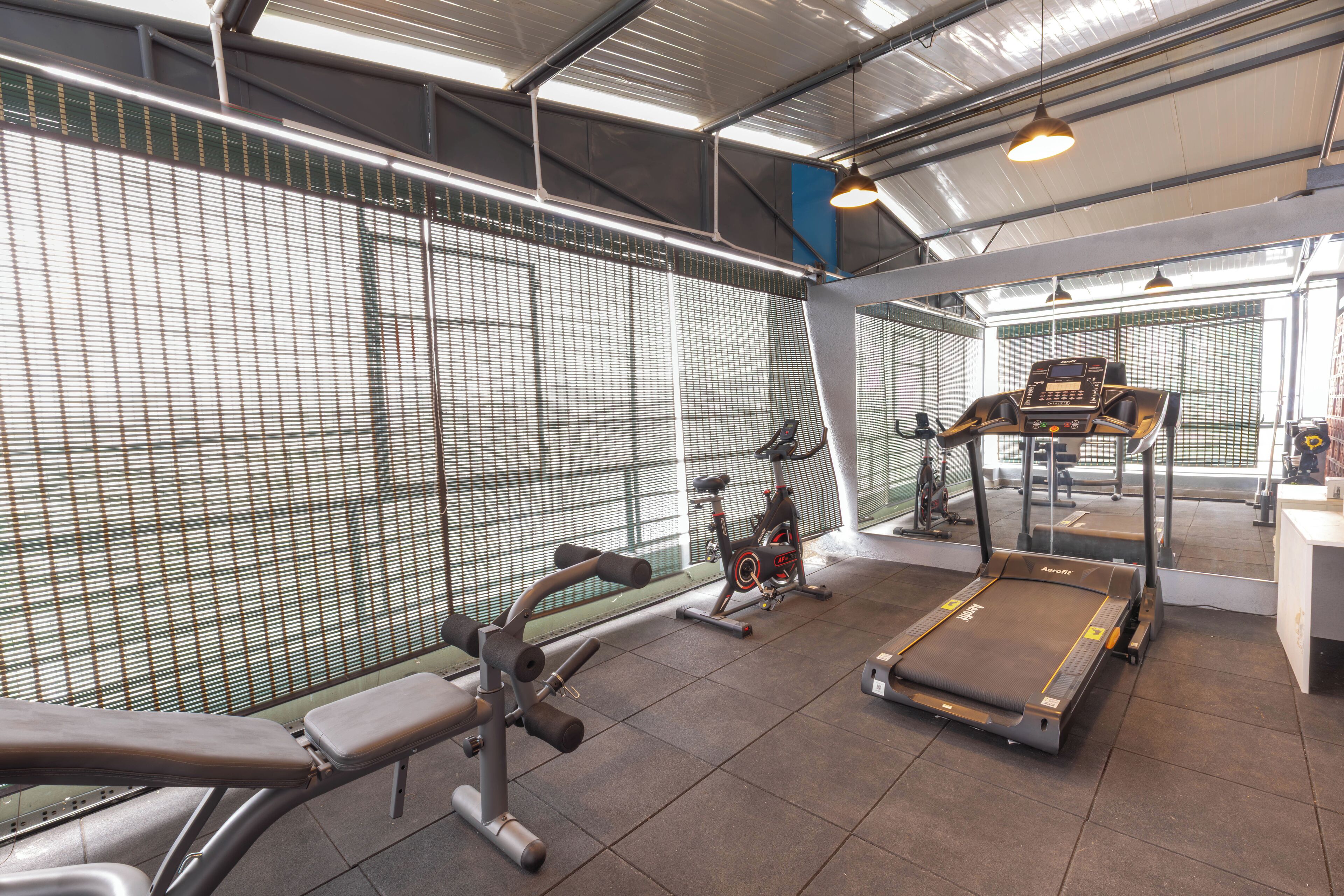 A gym with exercise equipment including a treadmill, stationary bike, and weight machines.