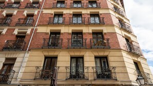 A multi-story building with a beige facade and red brick accents. It features multiple balconies with wrought iron railings. - Sandoval - Superior 1 Bedroom with Sofa Bed (Madrid)