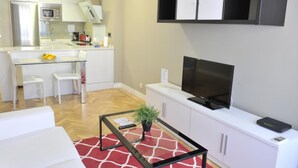 A modern apartment with a kitchen, dining area, and living room. - Goya - 1 Bedroom Apartment (Madrid)