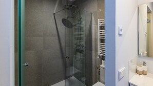 Ein modernes Badezimmer mit einer Duschkabine, einer weißen Toilette und einem weißen Waschbecken.