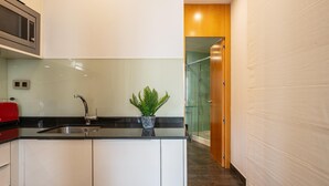 Una cocina moderna con un lavamanos de acero inoxidable, un electrodoméstico rojo y una planta en maceta.
