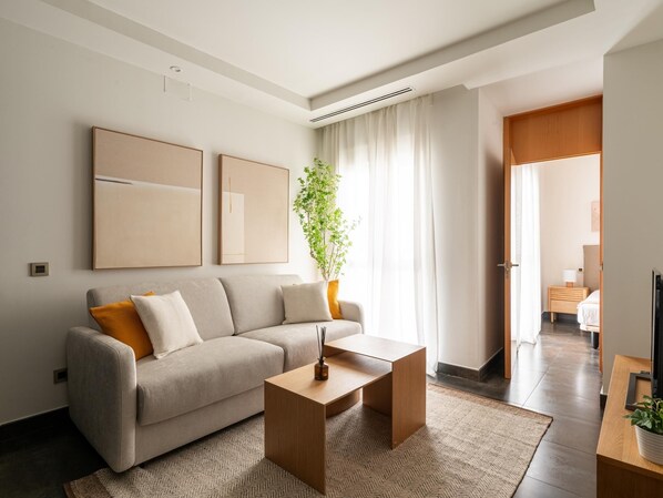 Un salon moderne avec un canapé, une table basse et une plante.