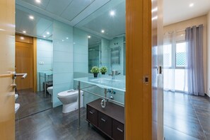 A modern bathroom with a glass shower enclosure, a toilet, a sink with a mirror, and a dark wooden cabinet. - Sandoval - 1 Bedroom with Sofa Bed (Madrid)