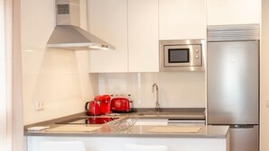 Una cocina moderna con electrodomésticos de acero inoxidable, una isla central con asientos y un microondas sobre el fregadero.