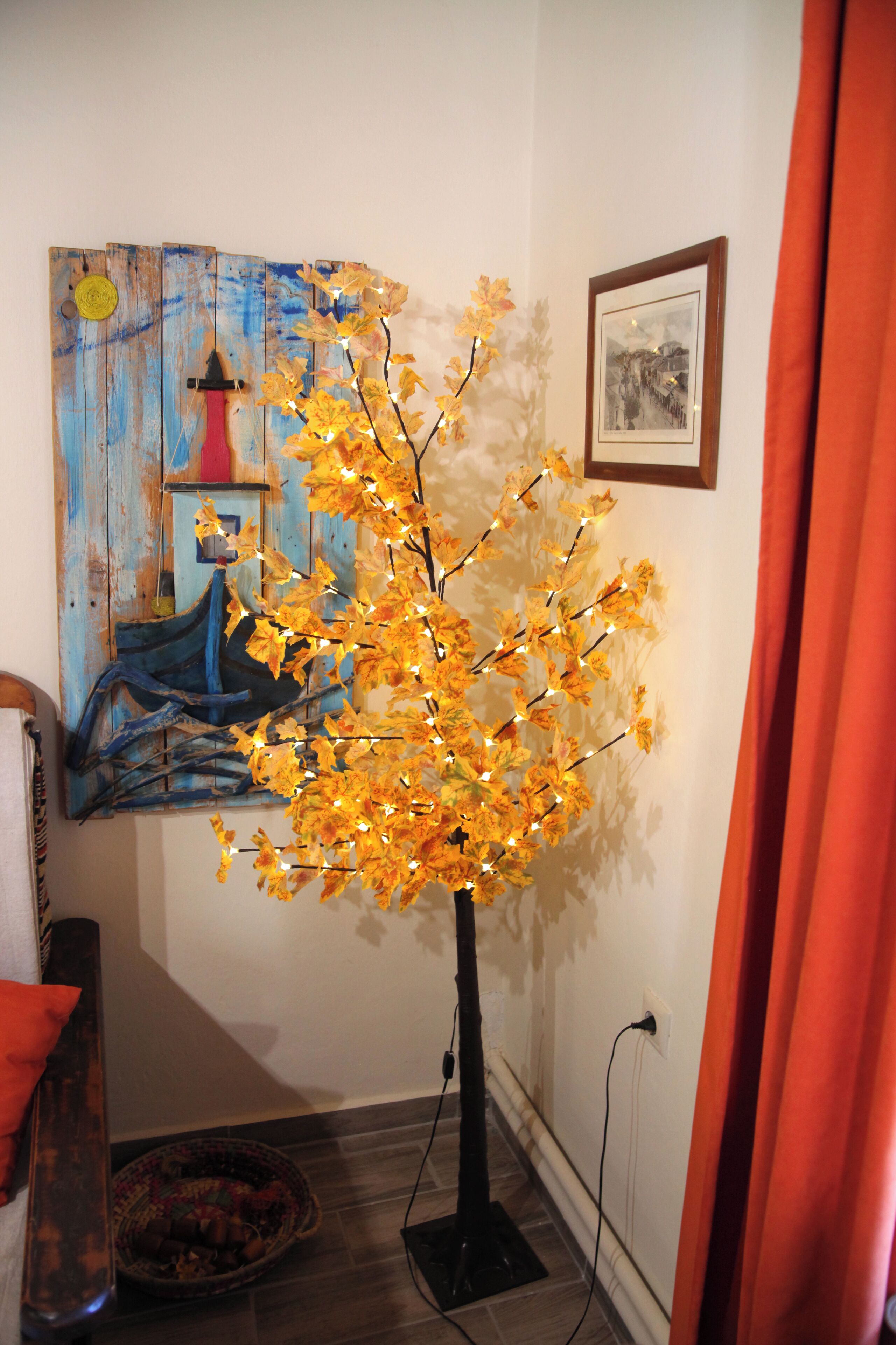 Een kamer met een vloerlamp, een schilderij en een lijst met een foto aan de muur.