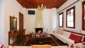 Una sala de estar acogedora con chimenea, muebles de madera y un sofá con cojines estampados.