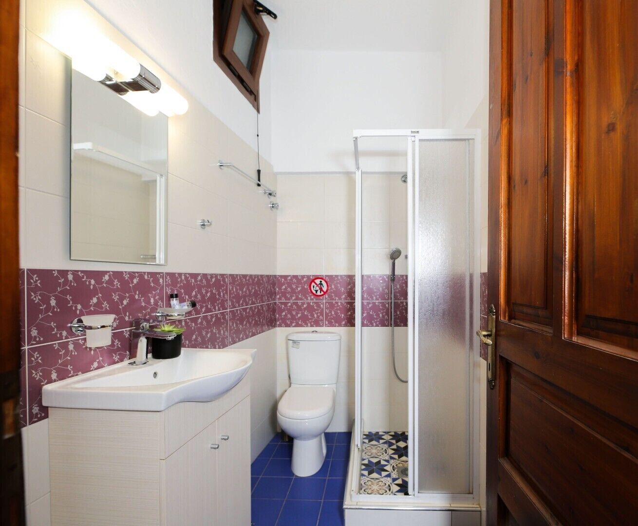A bathroom with a white sink, a toilet, and a glass-enclosed shower.